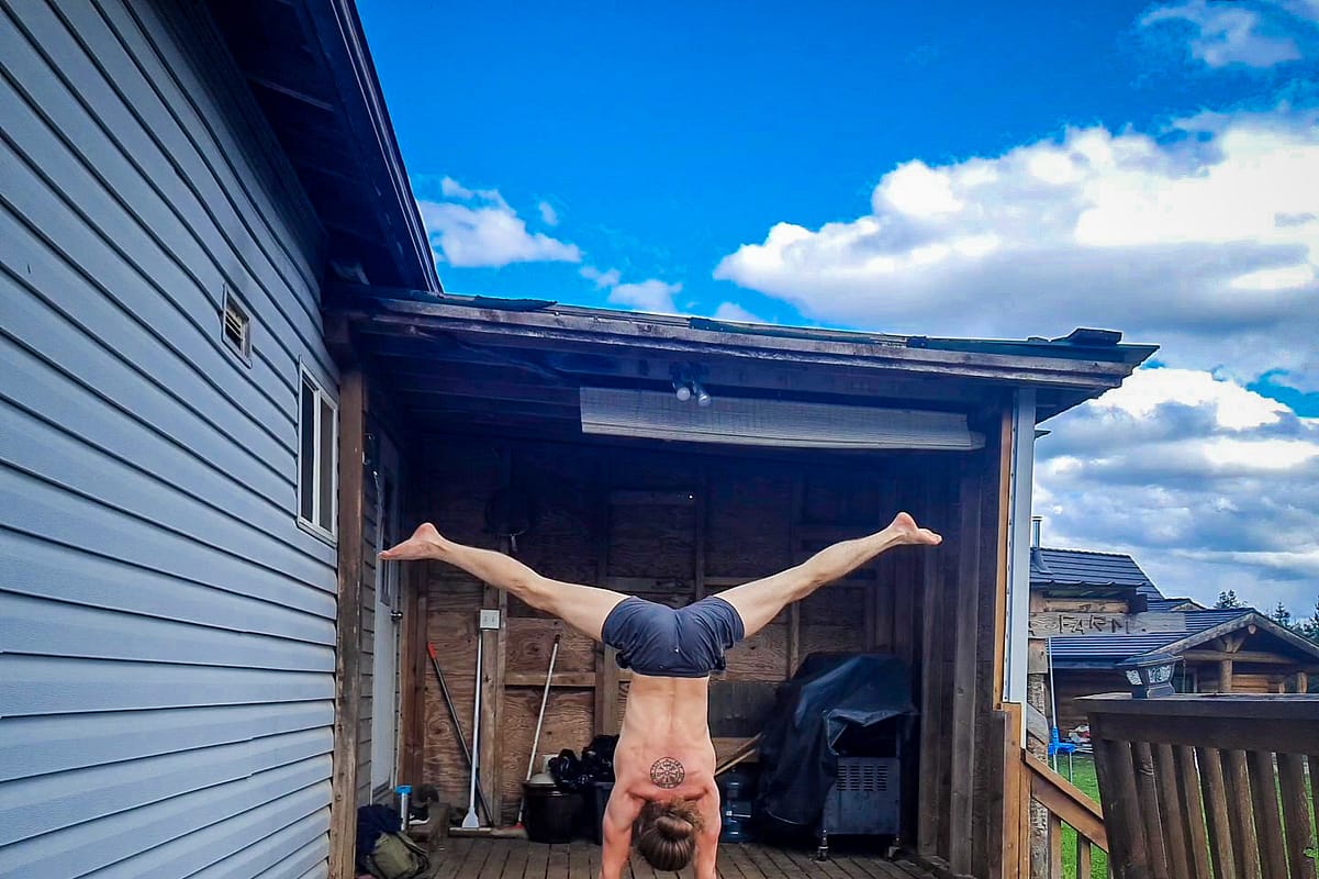 This image shows me doing a straddle handstand outdoors on a sunny day at Savanna Farms.