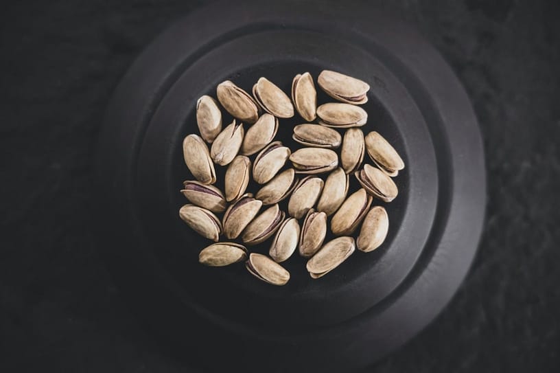 This image shows healthy fats in form of pistaccios in a bowl.